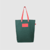 Custom premium tote bag in green canvas and pink leather handles and logo badge