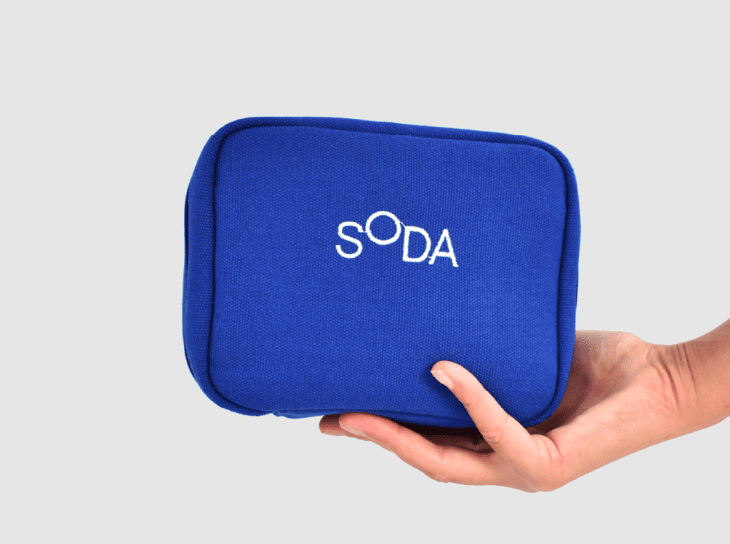 branded packaging blue zipped pouch with white SODA embroidery 