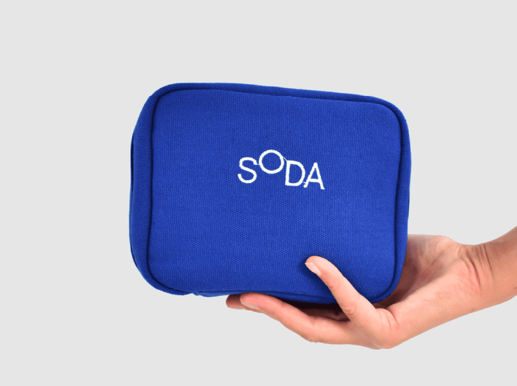 branded packaging blue zipped pouch with white SODA embroidery