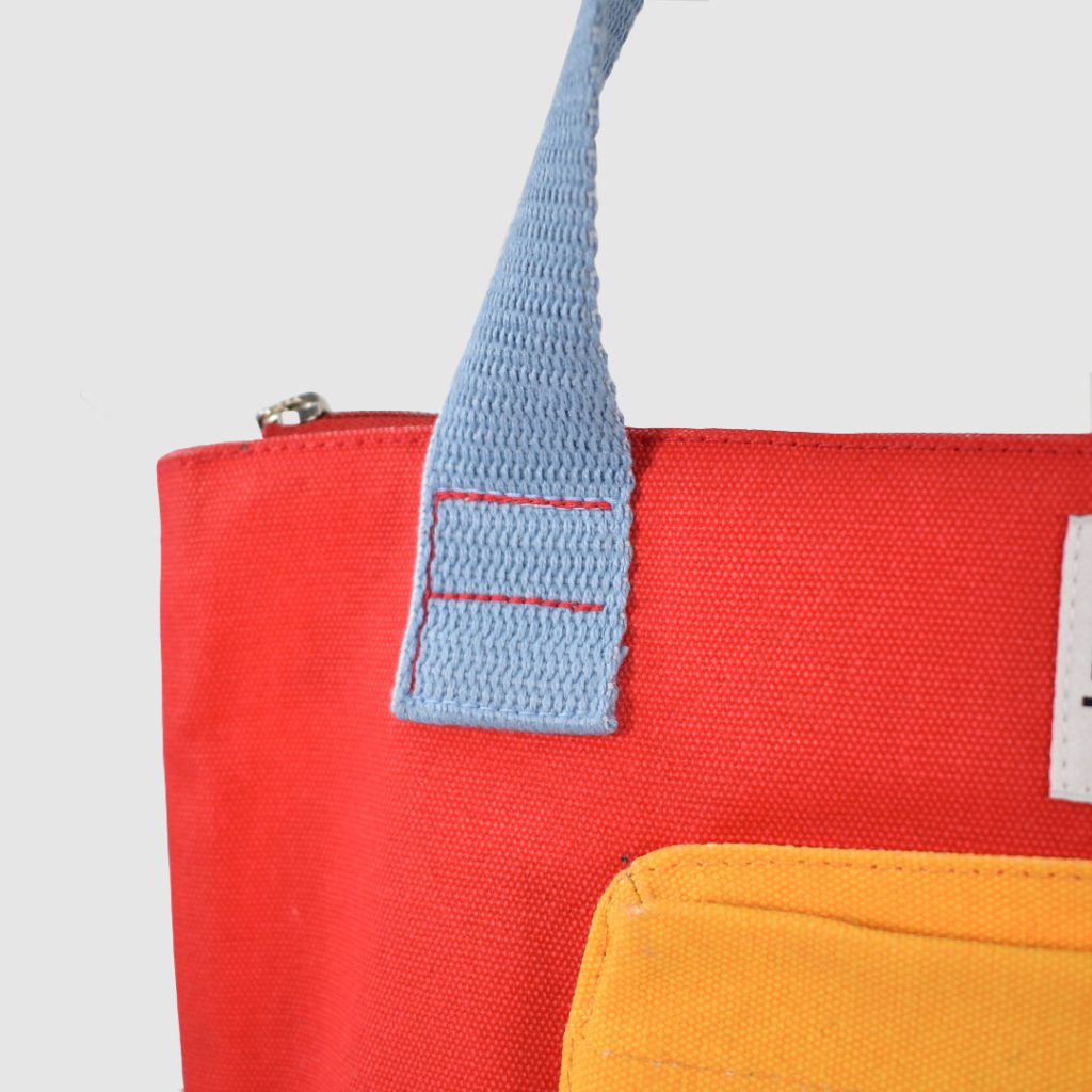 Custom heavyweight canvas bag with red stitching on blue handle