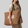 woman carrying brown oversized tote bag
