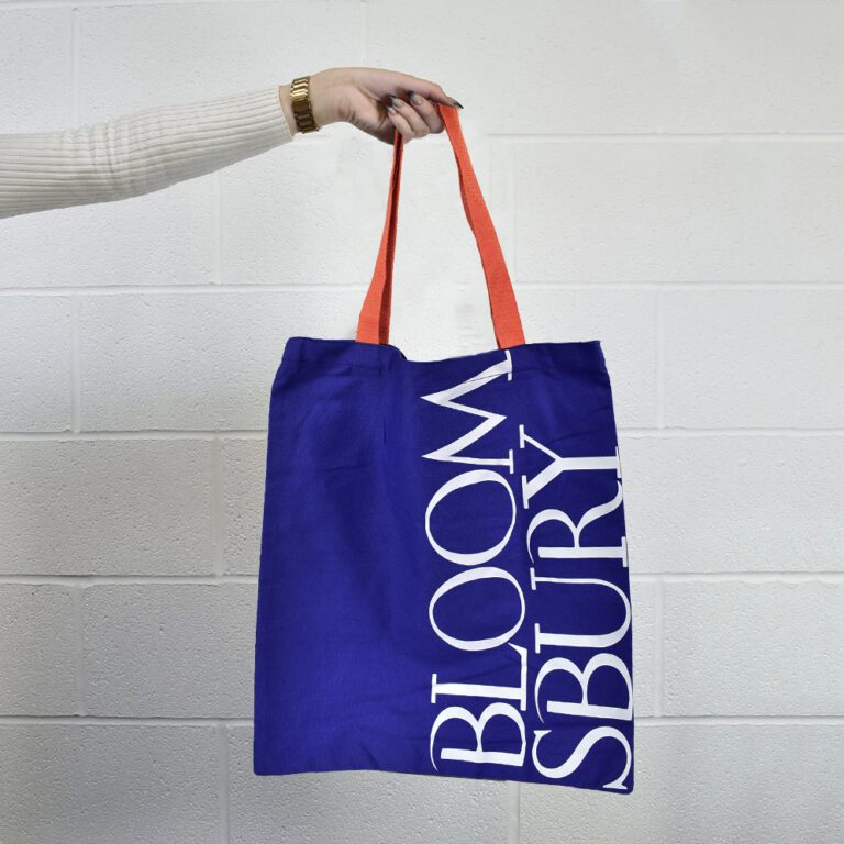 arm in white jumper holding royal blue bag with orange handles