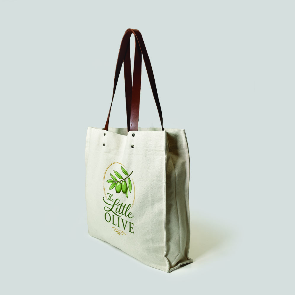 side view of natural colour canvas tote with brown leather handles