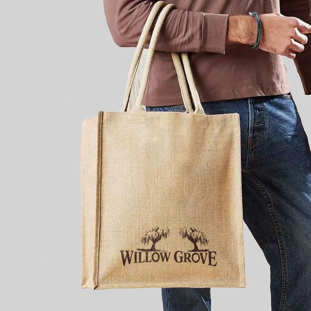 person wearing blue jeans holding brown jute bag with brown print
