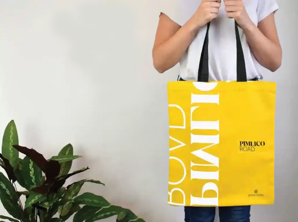 Person holding yellow tote bag